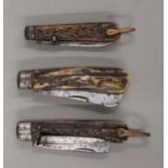 Three vintage antler-handled folding knives. The largest 12 cm long closed.