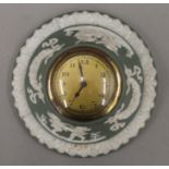 A Victorian jasperware table clock. 14 cm diameter.