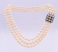 A three-strand pearl necklace, with a diamond and pearl set clasp,