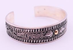 A Suarti silver bangle with 18 K gold detail. 1.5 cm maximum height.