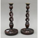 A pair of early 20th century oak barley twist candlesticks. Each 30 cm high.