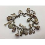 A Flat Curb Link Charm Bracelet, to hallmarked silver heart shape padlock style clasp, suspending