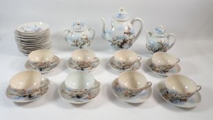 A Japanese eggshell tea service painted flowers and birds including eight cups, ten saucers,