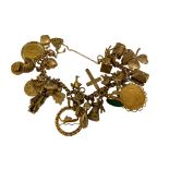 A 9ct gold charm bracelet with multiple attached g