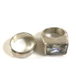 Two silver rings, wedding ring style and the other a clear stone