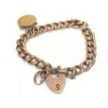 A 9ct rose gold curb link bracelet features a heart-shaped padlock clasp and 1903 half sovereign.