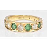 An 18ct gold half eternity ring set with round cut emeralds and diamonds, the largest emerald 0.25ct