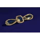 Victorian brooch set with a cushion cut and two pear cut citrines, with embossed floral border, 15.