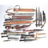Fourteen mainly North African tribal knives / short swords including a silver wire bound dagger,