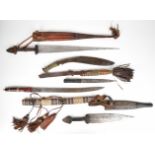 Four North African knives / short swords in tooled and worked leather scabbards, and a Gurkha