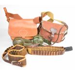 A collection of gun and shooting accessories including cartridge and game bags, shotgun cartridge