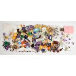 A collection of loose gemstones including pearls, lapis lazuli, mystic topaz, moonstone, amethyst,