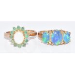 Two 9ct gold rings, one set with an opal surrounded by emeralds and the other with three opal