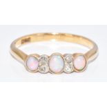 A c1900 18ct gold ring set with three opals and old cut diamonds, 2g, size M