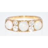 A c1910 18ct gold ring set with three round opal cabochons and four old cut diamonds, each diamond