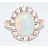 An 18ct gold ring set with an oval opal cabochon surrounded by diamonds, 4.8g, size N