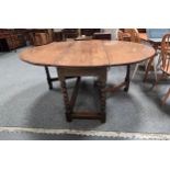An Antique English Oak Gate-leg Dining table, oval, with two drop-leaves, on bobbin-turned legs, the
