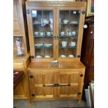 A Robert 'Mouseman' Thompson display cabinet, a glazed bookcase above latched cupboard, with
