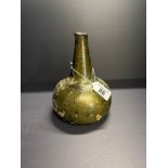 A green glass 'onion' wine bottle, early 18th Century, English or Dutch, with strong iridescent