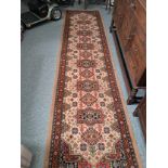 Hand crafted wool runner with traditional geometric pattern of reds, blues and cream within