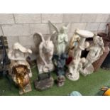 A collection of garden statues and figures including a plantstand with three cherubs; a nude