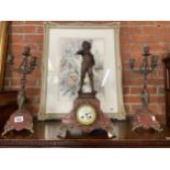 A red marble and gilt clock garniture, the figural clock surmounted with cast metal boy, together