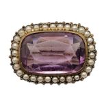 A 19TH CENTURY YELLOW METAL AMETHYST GLASS AND SEED PEARL BROOCH Rectangular form edged with seed