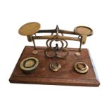 A SET OF EDWARDIAN MAHOGANY AND BRASS POST OFFICE SCALES Brass balance scale, on mahogany base,
