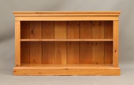A pine open low bookshelf - the moulded top over a single adjustable shelf with reeded edge, on a