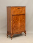 A 1950s walnut cocktail cabinet by Gold & Feather, of modest proportions - the top section with a
