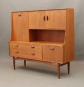 A G-Plan teak highboard with drinks cabinet - 1970s, factory red and silver label behind one door,