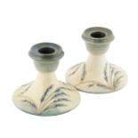 William Moorcroft (1872-1945): A Pair of Waving Corn Pattern Squat Candlesticks, on a matt blue