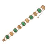 A Jade Bracelet five oval jade cabochon plaques in yellow rubbed over settings double chain linked