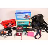 A collection of cameras, camcorders and a slide projector.