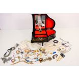 A musical jewellery box containing a quantity of costume jewellery to include rings, earrings,