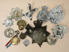 Box of military and other cap badges including Merseyside Police, Royal Scots,
