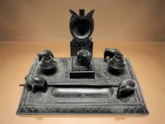 A 19th century ebony carved Indian writing stand surmounted by elephants
