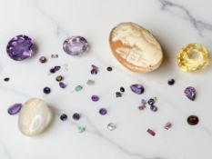 A small group of loose gem stones, the largest a citrine weighing approximately 7.