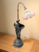 A patinated plaster lamp in the form of a semi nude lady carrying a basket,