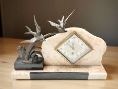 An Art Deco mantel clock surmounted by doves on a branch