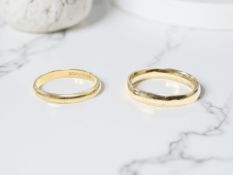 An 18ct yellow gold band ring, size N, together with a further yellow metal band ring.