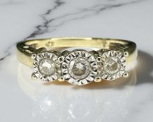 A 9ct yellow gold three stone diamond ring, the stated total diamond weight 0.25 carat, size O.