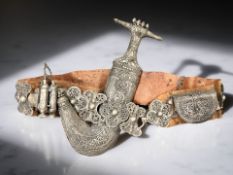 An Omani Jambiya in white metal mounts, on similar leather-backed belt,