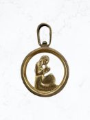 A 9ct yellow gold pendant depicting a figure praying,