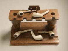 An oak pipe rack, width 25 cm, and several clay pipes.