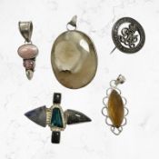 Four Continental white metal / silver mounted pendants and a service brooch,