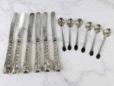 A set of six silver coffee spoons, and a set of six butter knives with silver handles.