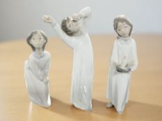 Three Lladro figures of children in night dress, tallest 22 cm.