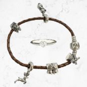 A Pandora woven leather and silver charm bracelet, plus a silver ring, both boxed.