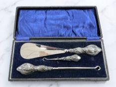 A cased silver-handled shoe horn and two button hooks